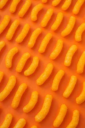 Salty, yellow corn sticks on a bright colored background in full screen.の写真素材