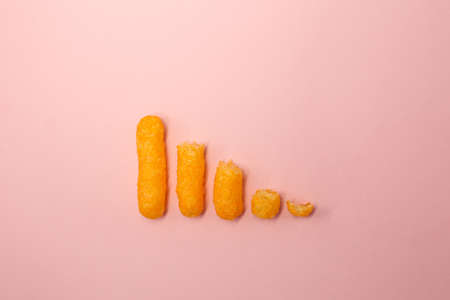 Salty, yellow corn sticks on a bright colored background in full screen.の写真素材