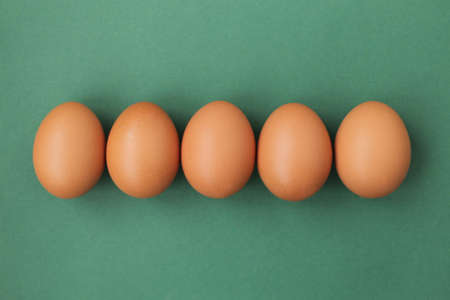 Chicken, fresh light brown eggs on a bright, light and even background.