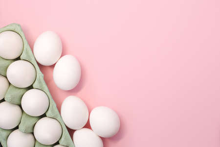 A lot of white chicken eggs on a colorful, even and bright background.