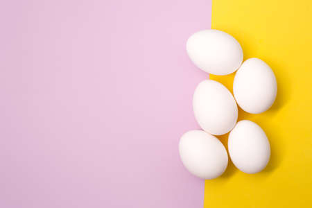 A lot of white chicken eggs on a colorful, even and bright background.の写真素材