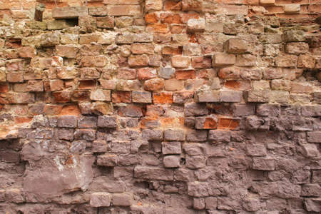 An old, shabby brick wall in full screen. old building.