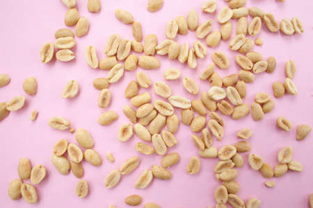 Roasted, salted, delicious peanuts on a bright, light background.の写真素材