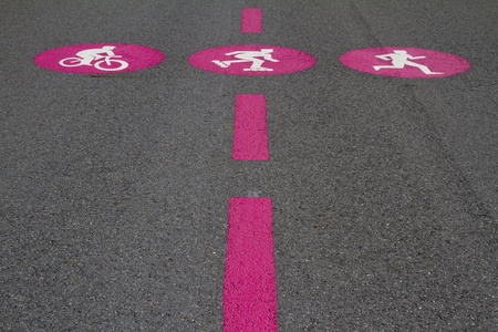 Pink pictograms of biker, skater, jogger on grey surfaceの写真素材