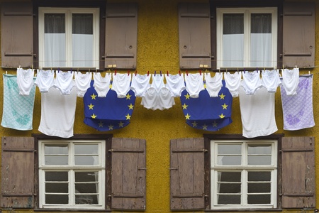Timber framing house with europe flag colored laundry hanging on a clotheslineの写真素材