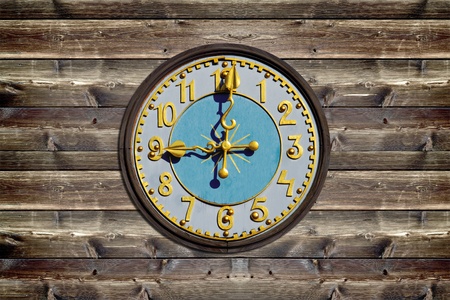 Wooden clock face on rustic wood boardの写真素材