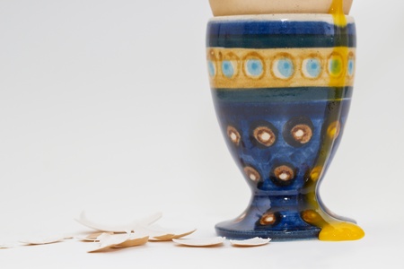 Egg yolk runs down a ceramic egg cup