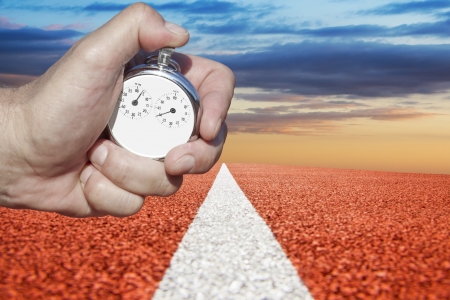 hand holds  historic stopwatch over racetrackの写真素材