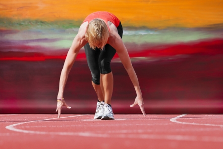 Female runner in start position with canvas in the backgroundの写真素材