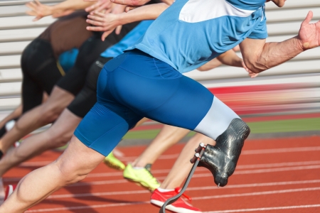 Handicapped sprinter starts short track race with unhindered athletesの写真素材
