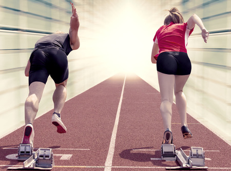 Male and female sprinter starting out of the blocks