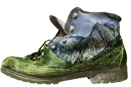 Isolated historic hiking boot with alp panorama overlay