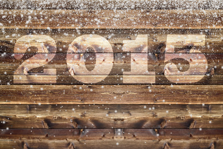 Wooden board with bleached out 2015 letter and falling down fluffy snowflakes of different sizeの写真素材