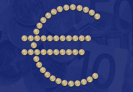 Group of one euro coins, euro symbol on FORMED as faded euro money backgroundの写真素材