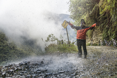 Bike adventure travel photo. Bike tourist  on the "road of death" enjoys the waterfall.の写真素材