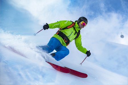Striking shot of a colorful clothed freerider skiing the snow wave. の写真素材