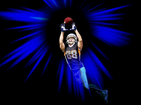 Black isolated american football player with the lucky number 88 on his shirt catches the ballの写真素材
