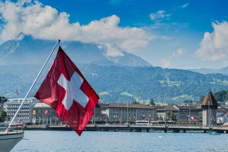 LUCERNE, SWITZERLAND - AUGUST 13, 2017: Cityscape of Lucerne with huge swiss flag in the foregroundのeditorial素材