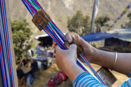 Closeup of female nepalese weaver creating a colorful belt,の写真素材
