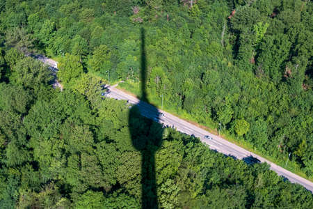 Shadow of Stuttgart television tower throws its shadow to the surrounding forest.の写真素材