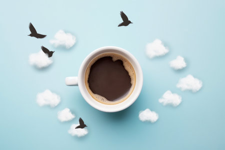 Coffee cup with clouds and birds on blue background, top viewの素材