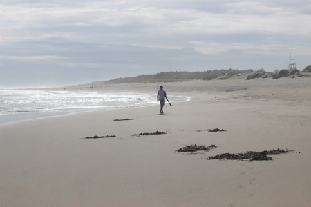 Shellfish hunter walks on a hot day at Parangtritis Beach, Yogyakarta, Indonesiaの写真素材