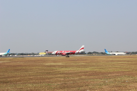 AirAsia Airbus A320-216 (9M-AQF) has just landed from Kuala Lumpur and Garuda Indonesia Boeing 737-8U3NG (PK-GMZ) is waiting for take-off at Adi Sumarmo International Airport, Solo, Indonesiaのeditorial素材