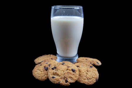 Glass of milk and chocolate chip cookies on a black background, isolatedの写真素材
