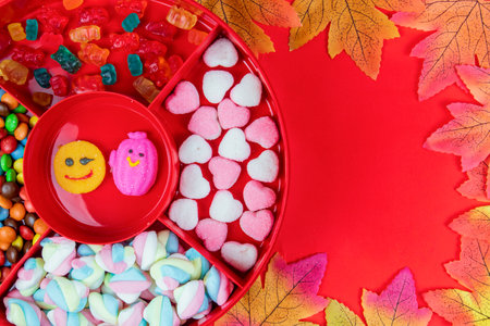 Set of different tasty candies in a red candy box on red background. variety of sweets and candiesの写真素材
