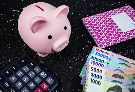 Piggy bank, calculator and banknote on black background.の写真素材