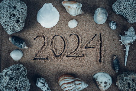 Handwritten 2024 on clean beach sand. Happy New Year