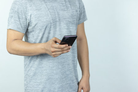 Asian man sending text message on smart phone on white Backgroundの写真素材