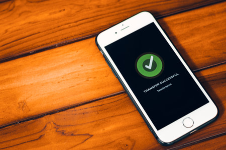 Money Transfers. Online payment. Smartphone with successful payment notification on screen on wooden backgroundの写真素材