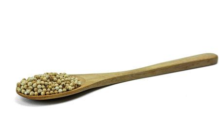 Close up of Coriander seeds on wooden spoon isolated on white backgroundの写真素材