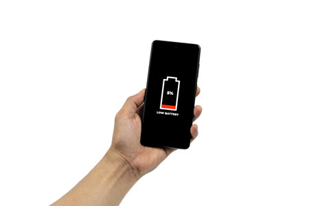 Cellular Problems and Energy Concepts. Man hand holding smart phone with low battery icon on screen...