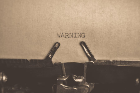 WARNING typed words on a vintage typewriter. Close up. Antique Typewriter.の写真素材