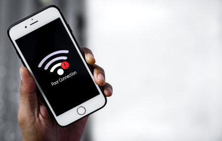 Man hand holding Smartphone with sign bad connection on screen. Communication, cellular problem concept.の写真素材