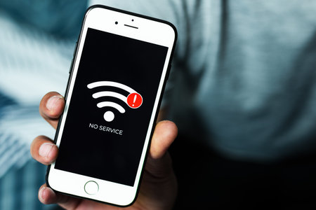 Close up of man hand holding smart phone with sign no service on screen. Communication, cellular problem, bad connection concept.の写真素材