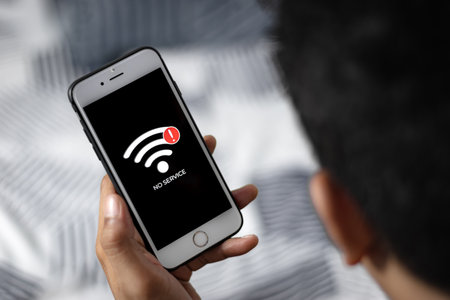 Man hand holding Smartphone with sign no service on screen. Communication, cellular problem, bad connection concept.の写真素材