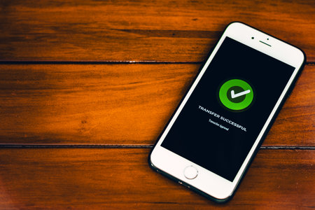 Money Transfers. Online payment. Smartphone with successful payment notification on screen on wooden...