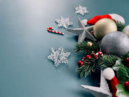 Christmas decorations, pine tree leaves, golden balls, snowflakes, red berries on blue backgroundの写真素材