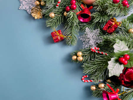 Christmas decorations, pine tree leaves, golden balls, snowflakes, red berries and golden berries on...