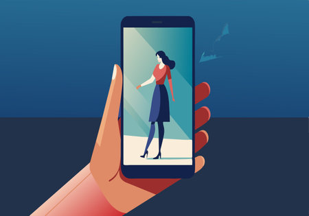 A hand holding a cell phone with a woman's face on the screen. The woman is wearing a red shirt and...