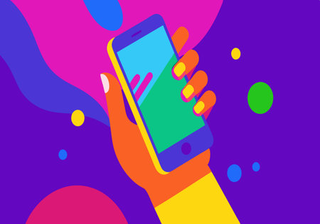 A hand holding a cell phone with a colorful background. Concept of fun and playfulness, as the...