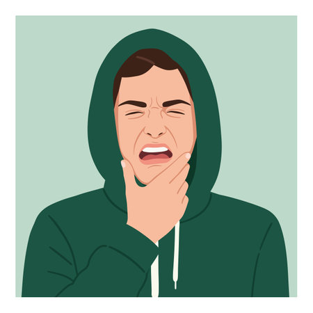 Illustration shows a young man in a green hoodie grimacing in pain while touching his chin, conveying discomfort and distress mood.のイラスト素材