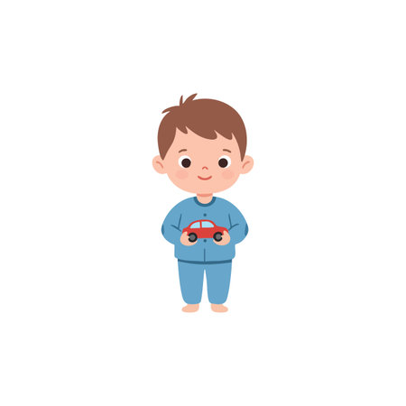 Young boy holds a red toy car wearing blue pajamas and standing barefoot on white background cheerful moodのイラスト素材