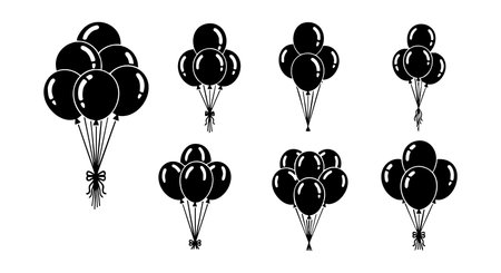 This vector illustration features seven different black balloon bunches tied with strings and bows for party decoration or celebration design in a simple style. festiveのイラスト素材