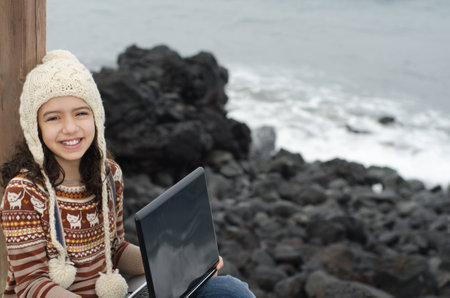 Child enjoying her time outdoor with the laptopの写真素材