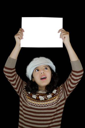 Child looking surprised at the white card that she holds upの写真素材