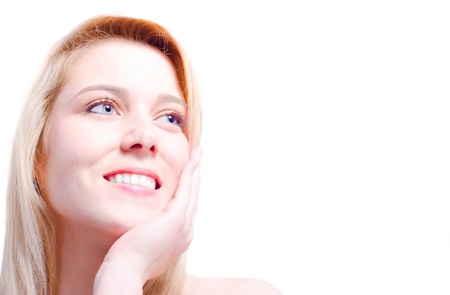 Blonde beautiful Caucasian woman caressing her face and smiling towards a copy spaceの写真素材